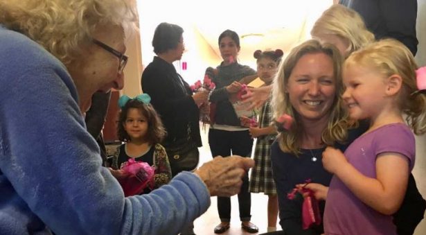 resident giving a flower to young child