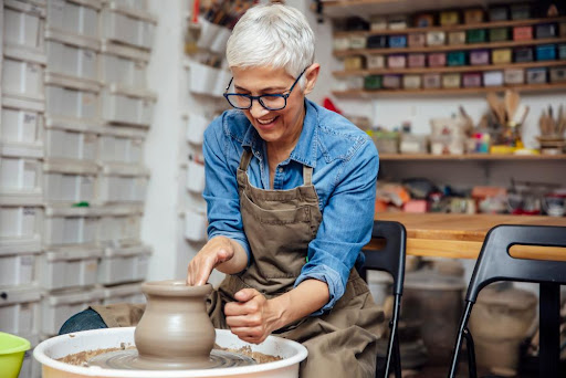senior woman using pottery wheel